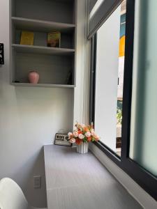 een vaas met bloemen op een vensterbank bij Kai's house in Ho Chi Minh-stad