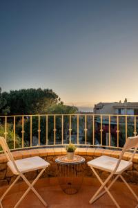 Un patio con dos sillas y una mesa en un balcón. en Villa Lolly, en Quartu SantʼElena