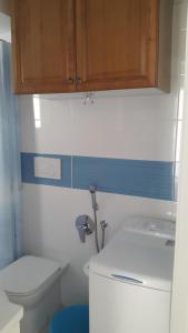 a bathroom with a toilet and a cabinet above a sink at Casa Delfino in Chioggia