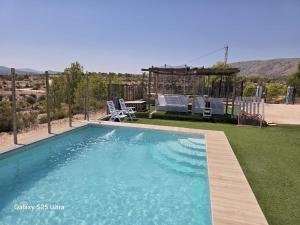 a swimming pool in a yard with a table and chairs at Casa Rural Natur Libre in Alicante
