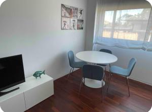 a living room with a table and chairs and a tv at Precioso Apartamento en la Playa de Illa de Arousa in Isla de Arosa