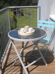 a table with two coffee cups and a blue chair at FerienLoft Eifeel Good - Natururlaub in Monschau in Monschau