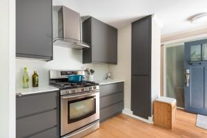 a kitchen with gray cabinets and a stove at Northern Stay in North Vancouver