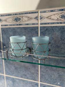 two cups on a glass table in a bathroom at Apartmány U Dvořáků in Janske Lazne