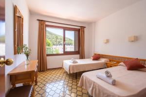 En eller flere senge i et værelse på Apartamentos Cala LLonga Playa + 66 billeder