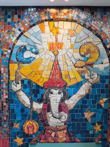 a mosaic mural on a wall with a person in front of aecycle at Coeo Frailes Design Apartments in Málaga