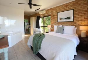 a bedroom with a large bed and a bath tub at Maleny Views Motel in Maleny