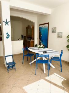 Un comedor con una mesa y sillas azules. en Accogliente a 2minuti dal mare, en Santa Maria Navarrese