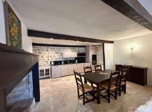 una cucina e una sala da pranzo con tavolo e sedie di Le Logis de la Bastide a Lauzerte