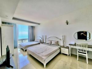 a bedroom with two beds and a mirror at OASKY Vũng Tàu - căn hộ 2 phòng ngủ sát biển in Vung Tau