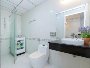 a bathroom with a toilet and a sink and a mirror at OASKY Vũng Tàu - căn hộ 2 phòng ngủ sát biển in Vung Tau