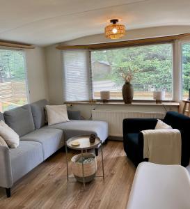 a living room with a couch and a table at Heerlijke ruime stacaravan met overdekte veranda en omheinde tuin ''Casa Elvina'' in Eext