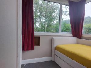 LawrenceにあるComfy Retreat with Viewsのベッドルーム1室(黄色いベッド1台、窓付)