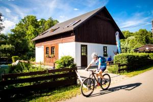 a boy riding a bike in front of a house at Turisticka ubytovna Cakle in Ústí nad Orlicí