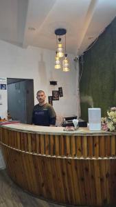 a man standing at a bar in a room at Hotel Ramya Village in Gwalior