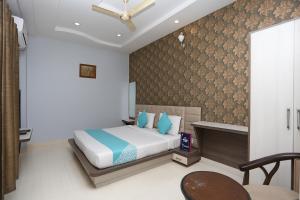 a bedroom with a bed with blue pillows at Hotel Ramya Village in Gwalior +7 photos