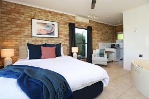 a bedroom with a large bed and a brick wall at Maleny Views Motel in Maleny +25 photos
