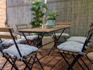 ein Tisch und Stühle mit Kissen auf einer Terrasse in der Unterkunft Beletage Cologne in Köln