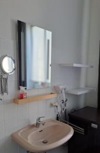 une salle de bain avec un lavabo et un miroir dans l'établissement Beletage Cologne, à Cologne