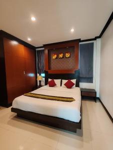 Un dormitorio con una gran cama blanca con almohadas rojas. en Aonang Chiva Villa, en Ao Nang Beach