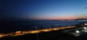 una vista del océano por la noche con un puente en ADM addumammà casa vacanze sul mare, en Portici