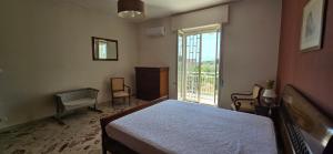 a bedroom with a bed and a large window at SOLUNTUM - locazione turistica in Santa Flavia +37 photos