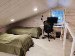 a bedroom with a desk and a computer in a attic at Tunturihovi A in Äkäslompolo