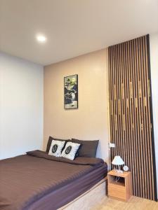 a bedroom with a bed and a wooden wall at N&N Home&Resort in Ratchaburi