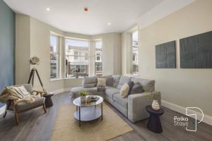 un salon avec un canapé et une table dans l'établissement Luxe Ami Ek South Shore GF Apartment by PolkaStays, à Blackpool