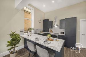 une cuisine avec un grand îlot avec des chaises dans l'établissement Luxe Ami Ek South Shore GF Apartment by PolkaStays, à Blackpool 33 autres photos