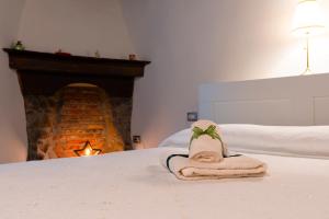 a towel sitting on top of a bed with a fireplace at Il Vicolo agli Orti - Centro storico - Lake Como in Bellano