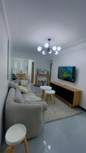 sala de estar con sofá, mesas y TV en Chellahomes, en Nairobi