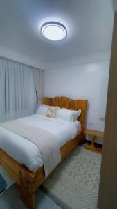 Un dormitorio con una gran cama de madera con una luz en Chellahomes, en Nairobi