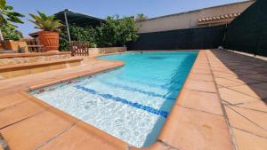 ein Swimmingpool mit blauem Wasser im Garten in der Unterkunft LoftCalJoan in Deltebre