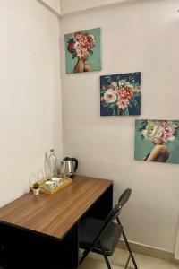 a dining room table with three paintings on the wall at Cozy Corner in Bengaluru