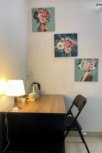 a desk with a lamp and three paintings on the wall at Cozy Corner in Bengaluru