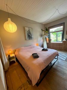 una camera da letto con un letto con un computer portatile sopra di Appartement aan de IJssel a IJsselmuiden Altre 6 foto