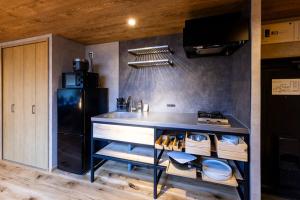 a kitchen with a counter with a sink and a refrigerator at tomarutoko OGUSU in Fukuoka +13 photos