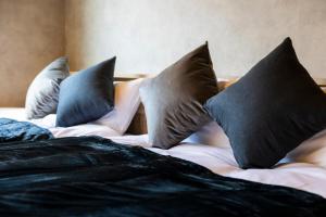 a bed with four pillows on top of it at tomarutoko OGUSU in Fukuoka