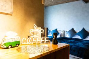 a table with a coffee sign next to a bed at tomarutoko OGUSU in Fukuoka