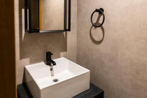 a bathroom with a white sink and a mirror at tomarutoko OGUSU in Fukuoka