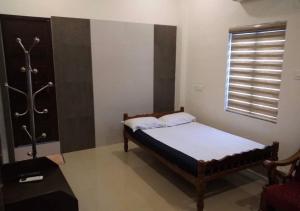 Un dormitorio pequeño con una cama y una ventana. en Alanchery Residency, en Cheruthuruthi