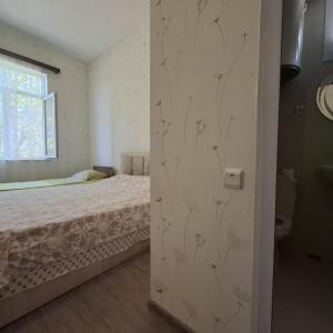 1 dormitorio con 1 cama y puerta corredera en Tsikhisdziri Black Sea, en Kobuleti