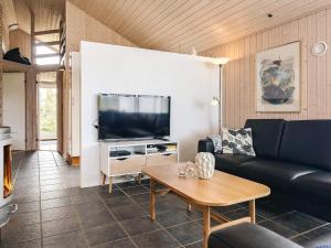 a living room with a couch and a tv at Modern Beach Retreat - By Traum Ferienwohnungen in Trudslev