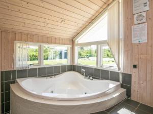 a large bath tub in a room with windows at Modern Beach Retreat - By Traum Ferienwohnungen in Trudslev