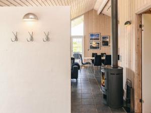 a room with a fireplace and a table with chairs at Modern Beach Retreat - By Traum Ferienwohnungen in Trudslev