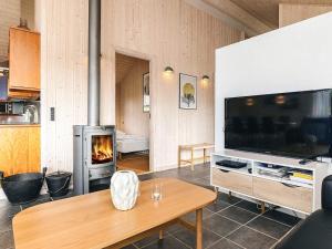 a living room with a television and a fireplace at Modern Beach Retreat - By Traum Ferienwohnungen in Trudslev
