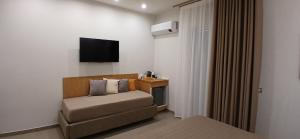 a hotel room with a couch and a television at COLIBRI Rooms in Agrigento +26 photos