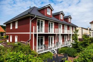 una gran casa roja con techo de gambrel en Schwedenhus 2 für 12 Personen, en Wangerooge