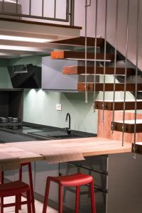 eine Küche mit einer Theke und zwei roten Hockern in der Unterkunft Living Calabriando in Reggio di Calabria